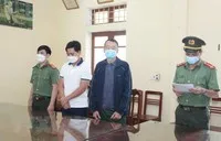 Cơ quan An ninh điều tra đọc lệnh bắt tạm giam đối tượng Khánh và An. (Ảnh: Hoàng Nguyên/TTXVN).