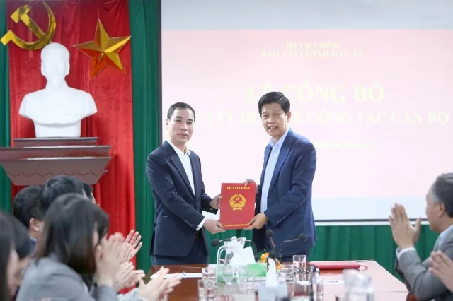 Thừa ủy quyền của Bộ trưởng Bộ Tài chính, Tổng Biên tập Báo Tài chính - Đầu tư Phạm Văn Hoành (bên phải) trao quyết định điều động, bổ nhiệm Phó Tổng Biên tập Báo Tài chính - Đầu tư cho ông Ngô Chí Tùng. Ảnh: Đức Minh