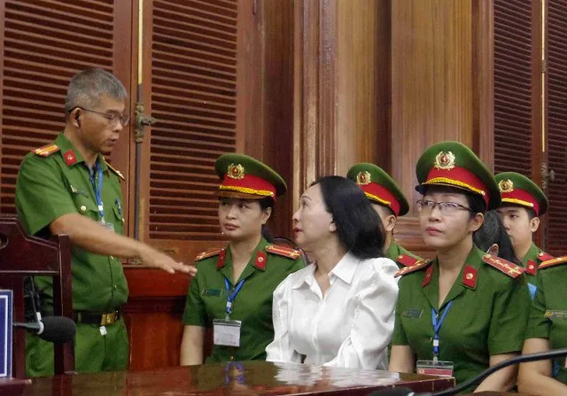Bị cáo Lan trao đổi với cán bộ áp giải trước phiên tòa.
