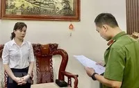 Cán bộ Phòng Cảnh sát điều tra tội phạm về tham nhũng, kinh tế, buôn lậu Công an tỉnh Cao Bằng tống đạt quyết định khởi tố bị can, lệnh bắt bị can để tạm giam đối với bà Hoàng Thị Xuyến, Giám đốc Ban quản lý dự án đầu tư và xây dựng huyện Bảo Lạc. (Ảnh: TTXVN phát).