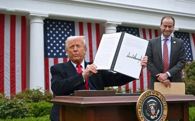 Tổng thống Mỹ Donald Trump cầm trên tay sắc lệnh hành pháp đã ký sau khi phát biểu về thuế đối ứng tại một sự kiện diễn ra ở Nhà Trắng vào ngày 2/4/2025. Ảnh: AFP