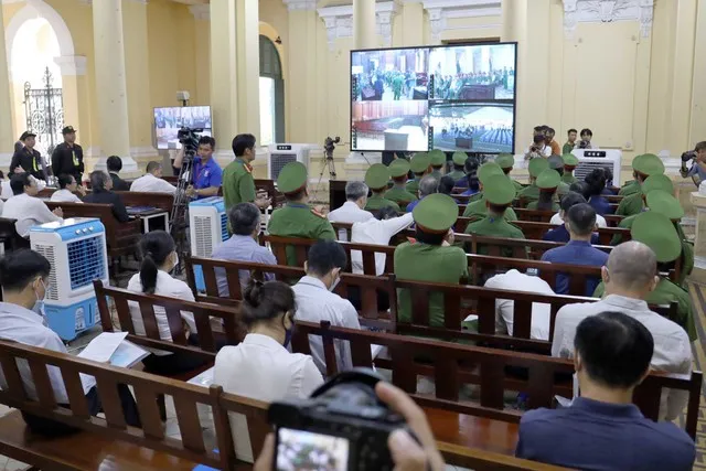 Các bị cáo theo dõi phiên toà thông qua màn hình bên ngoài phòng xét xử.