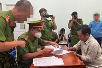 Cơ quan cảnh sát điều tra Công an tỉnh Bình Dương bắt tạm giam ông Lê Anh Xuân (áo xám bên phải) chủ quán karaoke An Phú