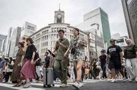 Người đi bộ băng qua đường ở khu mua sắm Ginza của thủ đô Tokyo, Nhật Bản. Ảnh: AFP