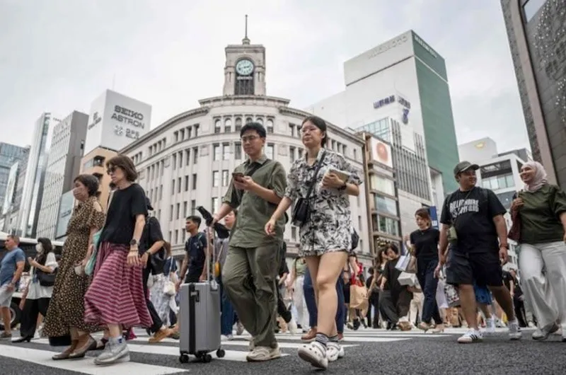Người đi bộ băng qua đường ở khu mua sắm Ginza của thủ đô Tokyo, Nhật Bản. Ảnh: AFP