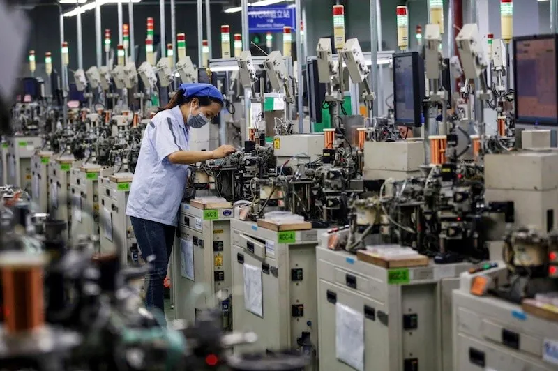 Công nhân làm việc tại dây chuyền sản xuất cuộn cảm của một nhà máy ở thành phố Tô Thiên, tỉnh Giang Tô, Trung Quốc. Ảnh: AFP