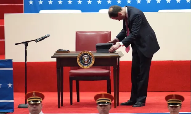 Chiếc bàn và ghế nhỏ với một chồng giấy tờ dường như là các sắc lệnh mà ông Trump sẽ thực hiện ký công khai.