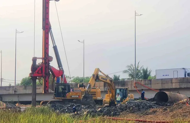 Một bên là dòng xe lưu thông đông đúc, một bên là công trường thi công kéo dài theo hành lang tuyến.