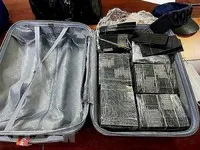 Cơ quan chức năng thu giữ số lượng lớn tiền mệnh giá 100 USD bị nhuộm đen bằng hóa chất. (Ảnh: TTXVN phát)