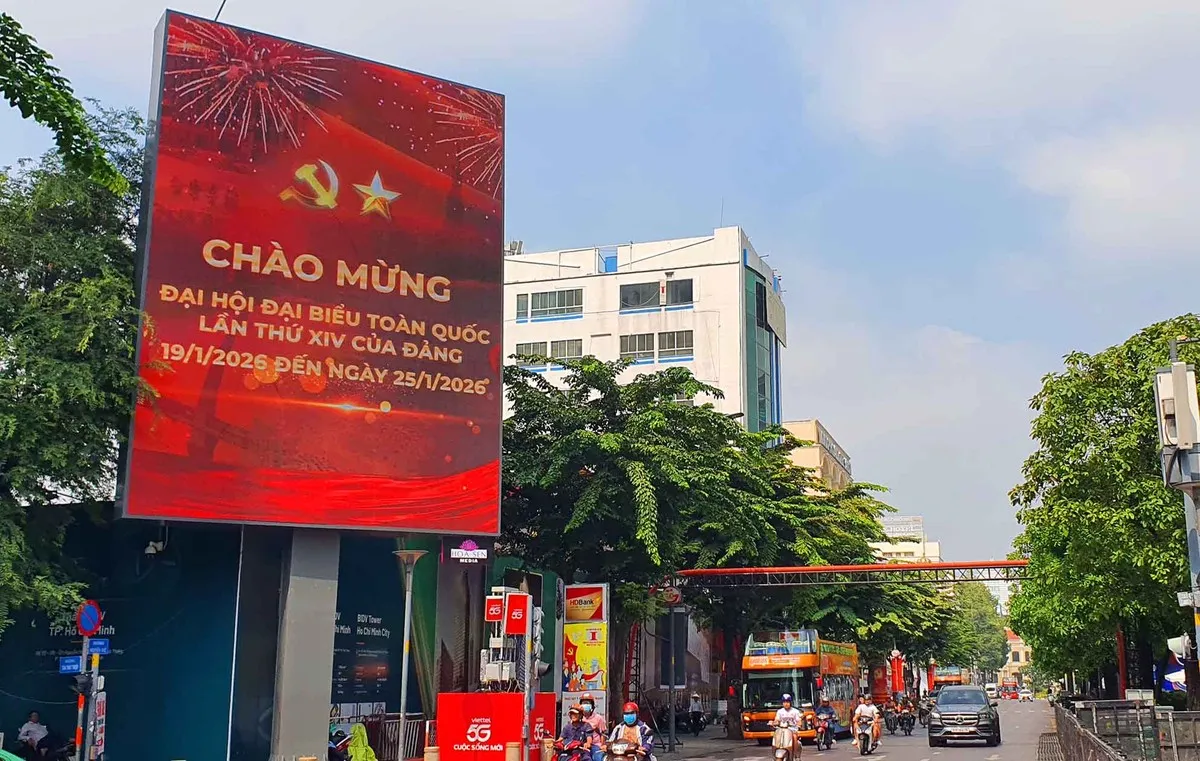 Đường Nguyễn Huệ ngày cuối tuần, rực sáng sắc đỏ khi các màn hình LED đồng loạt hiển thị thông điệp chào mừng Đại hội Đảng, thu hút sự chú ý của người dân và du khách.