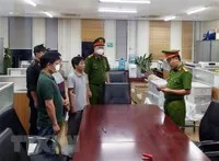 Lực lượng chức năng đọc lệnh bắt các bị can liên quan đến vụ án xảy ra tại Bệnh viện Đa khoa Đồng Nai, Công ty AIC và các đơn vị liên quan. (Ảnh: Phạm Kiên/TTXVN)