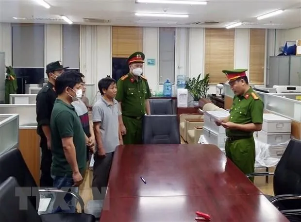 Lực lượng chức năng đọc lệnh bắt các bị can liên quan đến vụ án xảy ra tại Bệnh viện Đa khoa Đồng Nai, Công ty AIC và các đơn vị liên quan. (Ảnh: Phạm Kiên/TTXVN)