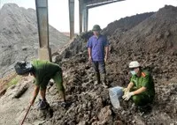 Lực lượng chức năng kiểm tra khu vực chôn lấp chất thải. Ảnh: BCA